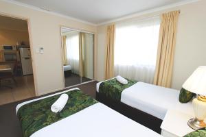 Postel nebo postele na pokoji v ubytování The Palms Motel