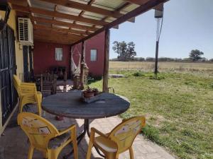 a patio with a table and chairs on a house at El Resueyo de Saladillo in Saladillo