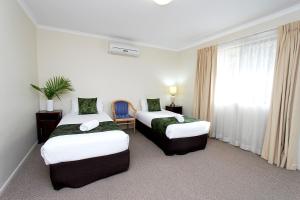 Postel nebo postele na pokoji v ubytování The Palms Motel