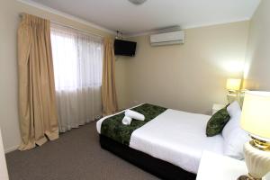 Postel nebo postele na pokoji v ubytování The Palms Motel