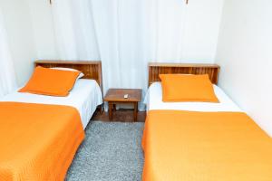 2 camas con almohadas de color naranja en una habitación en Francis Nook Bourg Mulatresse Room, en San Juan