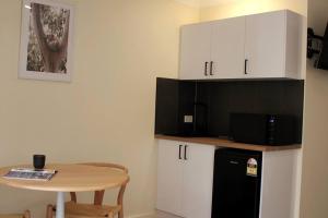 a kitchen with a small table and a black refrigerator at Marengo Beach Studio 4- Pet Friendly in Marengo