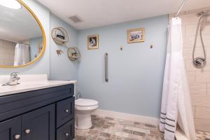 ein Badezimmer mit Waschbecken, Toilette und Spiegel in der Unterkunft MCM Retro Beachfront Studio Great View, King Bed Remodeled in Daytona Beach