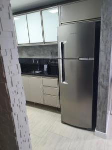 a stainless steel refrigerator in a kitchen with windows at Apartamento 509 Gravataí in Gravataí