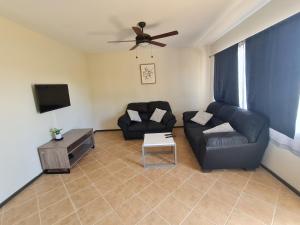 uma sala de estar com um sofá e uma televisão em JFM Apartamento em Coco