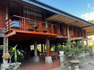 - un bâtiment avec un balcon, une table et des chaises dans l'établissement VuLinh Family Homestay, à Yên Bình