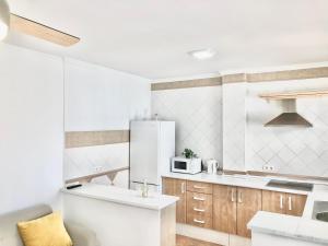 eine weiße Küche mit Spüle und Kühlschrank in der Unterkunft Alhattic in Alhaurín el Grande