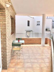 a balcony with a table and chairs on a brick wall at Alhattic in Alhaurín el Grande