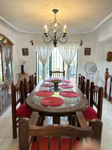a dining room table with chairs and a chandelier at Casa Estrella Oaxaca in Oaxaca City