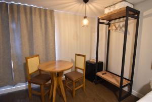 a room with a table and chairs and a bed at Pousada Villa Manso in Conceição da Ibitipoca