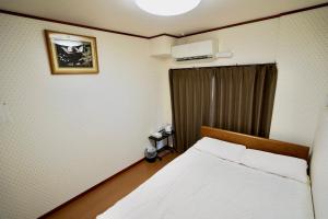 um quarto com uma cama branca e uma janela em 寧寧の道（Nenenomichi） em Quioto
