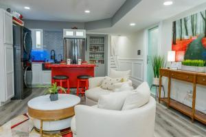 a living room with white furniture and a kitchen at The Honey Suite & Spa in Westminster