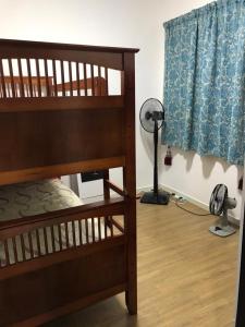 龍溪村的住宿－AZ Sensory Residence，一间卧室设有两张双层床和风扇