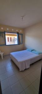塔曼達雷的住宿－Casa12_Carneiros，一间卧室设有一张大床和一个窗户。