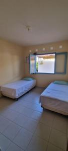 2 camas en una habitación con ventana grande en Casa12_Carneiros, en Tamandaré