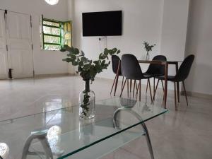 a living room with a glass table and a vase with a plant at Hermosa Casa para compartir en Familia y amigos in Jericó