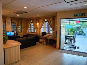 a living room with a couch and a table with chairs at Vintage Guesthouse in Tanah Rata