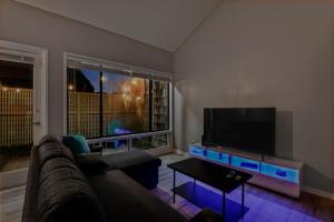 a living room with a couch and a flat screen tv at NEW King with Loft Beach Near Gulf in Gulfport