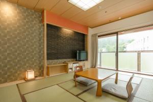 sala de estar con mesa y ventana grande en Diamond Arima Onsen Society en Kobe