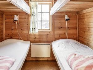 twee bedden in een kamer met houten wanden bij Holiday home JÄRPEN II in Järpen