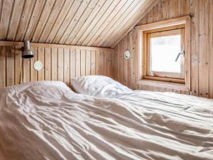 Cama en habitación de madera con ventana en Holiday home JÄRPEN II en Järpen