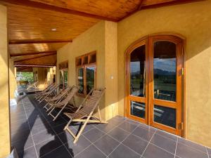 - une rangée de chaises assises sur la terrasse couverte d'une maison dans l'établissement Sky Bay Ha Giang, à Ha Giang