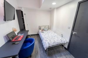 a room with a bed and a desk with a laptop at Stylish cosy studio in Selly Oak in Birmingham