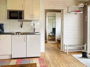 a kitchen with white cabinets and a sink at Holiday home ARKELSTORP in Arkelstorp