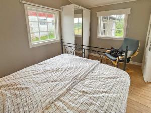 1 dormitorio con 1 cama, 1 silla y 2 ventanas en Holiday home ARKELSTORP en Arkelstorp