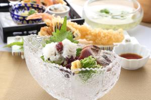 a glass bowl filled with food on a table at Hotel Binario Saga Arashiyama in Kyoto