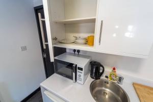 Una pequeña cocina con fregadero y microondas. en Modern studio available close to the city, en Birmingham 7 fotos más