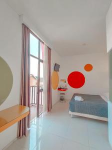 a bedroom with a bed and a large window at Dewarna Hotel Arifin in Malang +12 photos