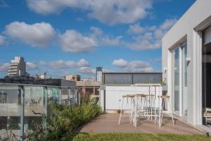 a balcony with chairs and tables on a building at Grid Suites Charcas in Buenos Aires