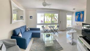 a living room with a blue couch and a glass table at Intracoastal sunsets condo building with 2 beds or 1 bed units private heated pool in Pompano Beach