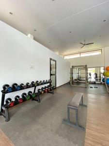 Monde Residence H12 Batam Centre في Sengkuang: صالة رياضية مع مقعد ومجموعة من المعدات