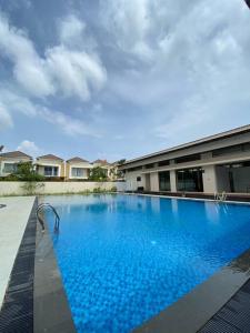 uma grande piscina azul em frente a um edifício em Monde Residence H12 Batam Centre em Sengkuang