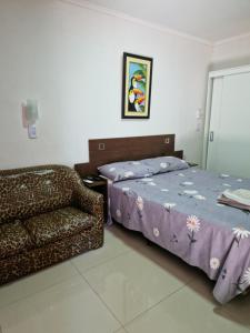 1 dormitorio con 1 cama y 1 sofá en Pacurí Hotel en Puerto Iguazú