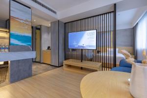 a hotel room with a television and a living room at Tuke China Hotel -Wenzhou South Bus Terminal in Wenzhou