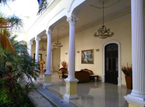 a large lobby with white columns and a couch at Gran Real Yucatan in Mérida
