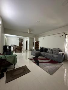ein großes Wohnzimmer mit einem Sofa und einem Tisch in der Unterkunft GreyRooms in Dhaka