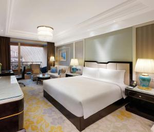 InterContinental Chengdu Global Center, an IHG Hotel في تشنغدو: غرفة نوم بسرير كبير وغرفة معيشة