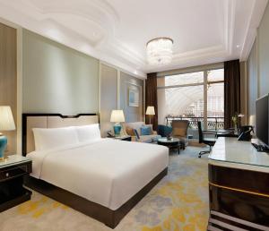 InterContinental Chengdu Global Center, an IHG Hotel في تشنغدو: غرفة نوم بسرير ابيض وغرفة معيشة