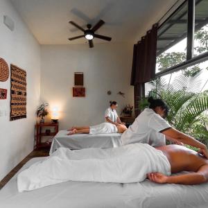 two people laying on beds in a bedroom at Hotel Finca 360 in Marsella