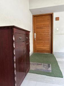 a wooden cabinet in a room with a door at GreyRooms in Dhaka