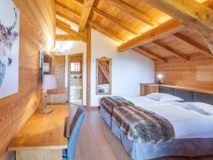 a bedroom with a large bed and wooden ceilings at Chalet skis aux pieds avec spa et sauna, Alpe d'Huez - FR-1-645-41 in LʼHuez
