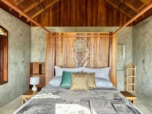 a bedroom with a large bed with a wooden headboard at Arasi Resort in Kalpitiya