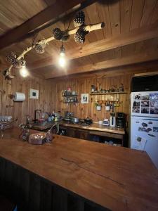 a kitchen with wooden walls and a white refrigerator at Hostal waiwen in Matanzas