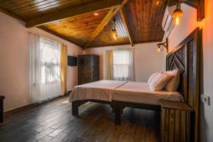 um quarto com uma cama grande num quarto com pisos em madeira em Belong Butik Otel em Cesme