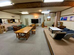 duży pokój ze stołami i krzesłami w obiekcie Mashuko Youth Hostel w mieście Teshikaga