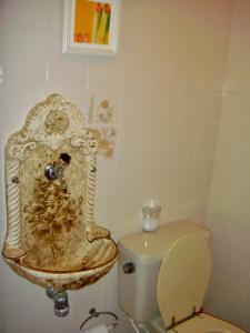 a bathroom with a toilet and a sink at Casa Enorme em condominio, 4 suites, piscina com cascata, cozinha gourmet com churrasueira e fundo com pier no rio para práticas aquaticas in Bertioga